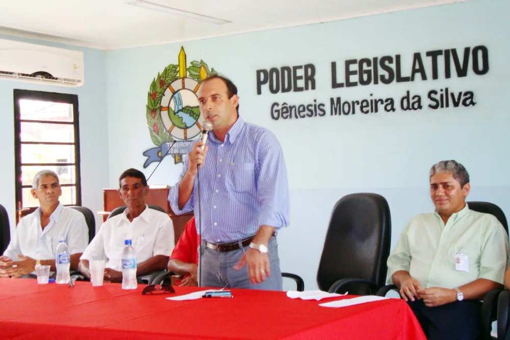 Ari Saraiva ao microfone em sessão da Câmara, sob o brasão do Poder Legislativo.